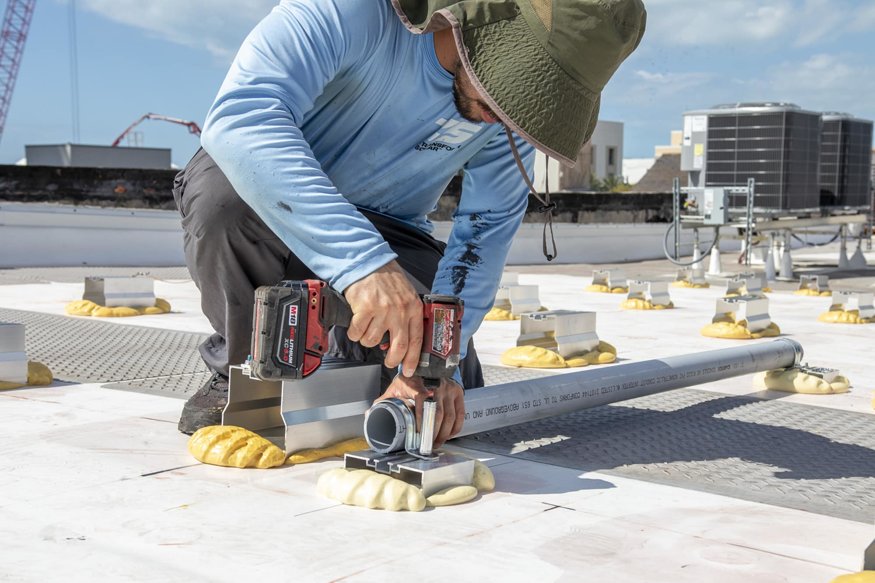 Technician secures wiring conduit to mounting brackets.
