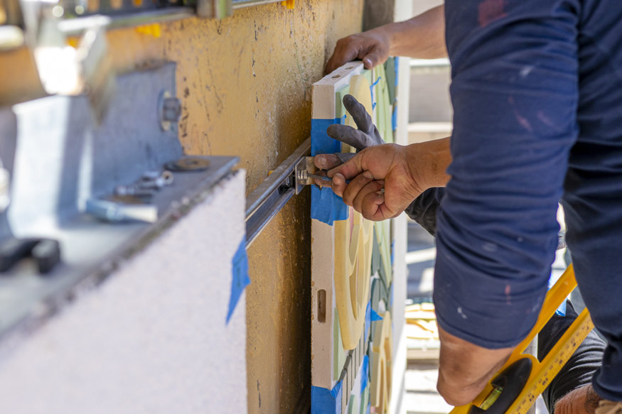 The colorful tile frieze is set in place using a concealed mounting system.