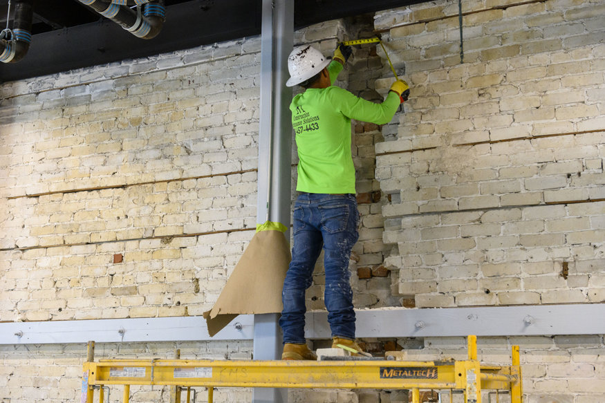 Mason measuring the bricks for extraction