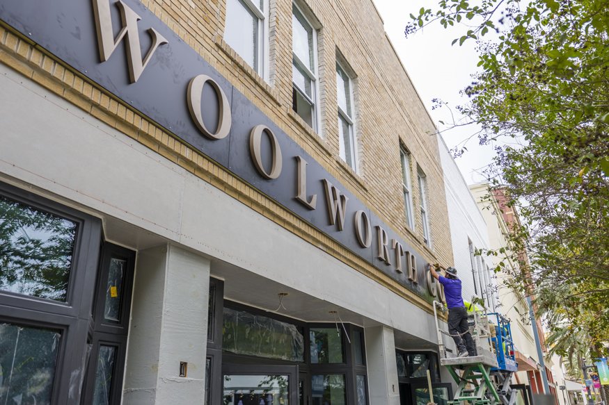 Restored Woolworth sign on historic façade.