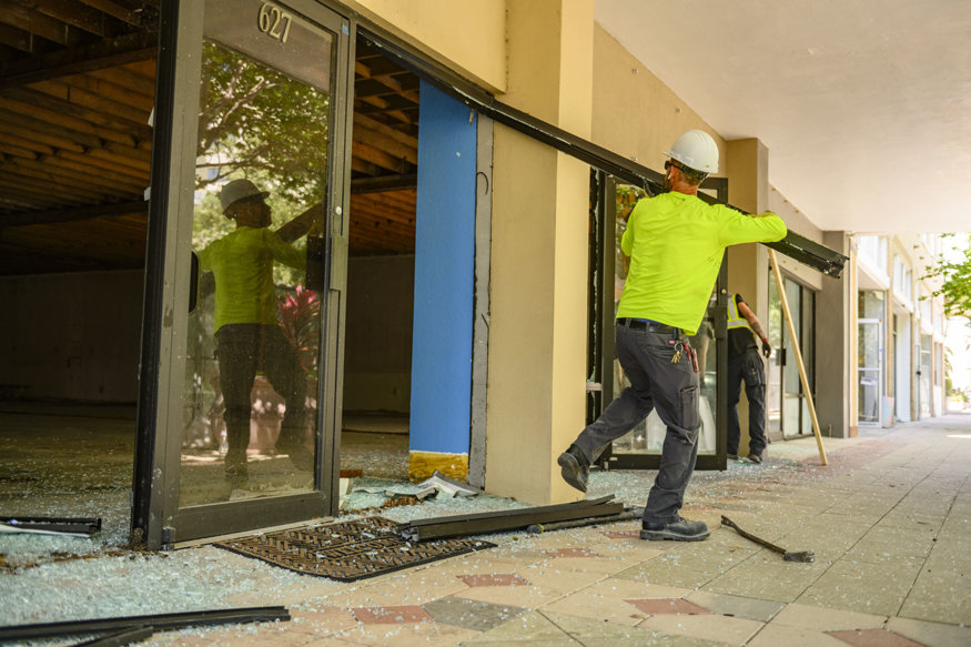 Crew removing aluminum storefront framing. 