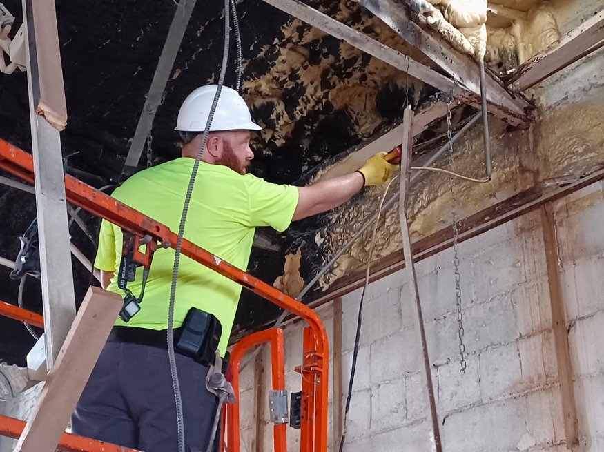 Workers removing wall wiring.