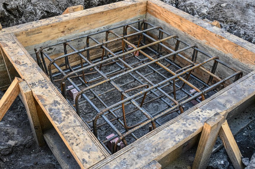 Rebar grid secured inside wood foundation footing form.