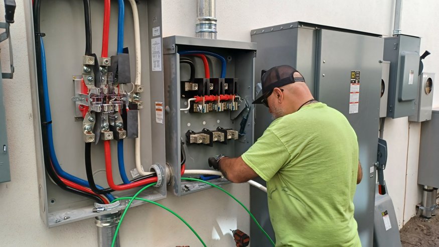 Multiple electrical disconnects mounted on building wall.
