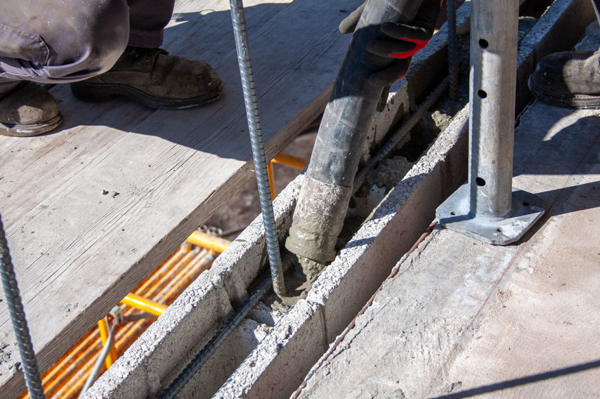 Concrete fills reinforced CMU cell.