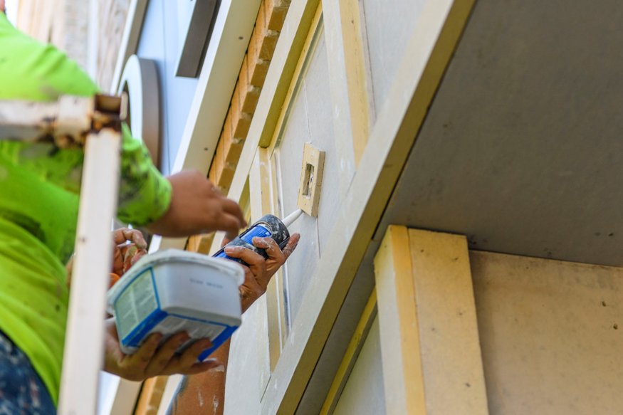Crew sealing storefront trim.