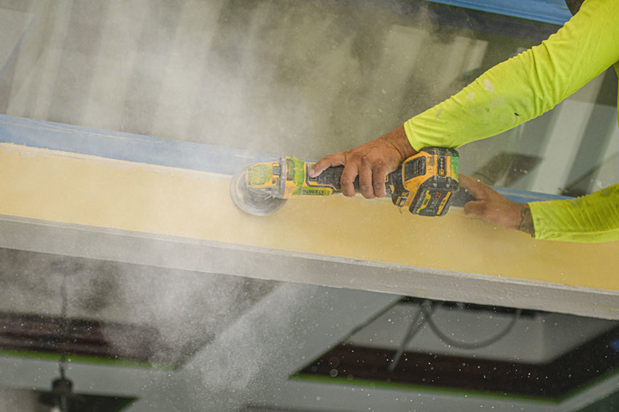 Worker sanding trim.