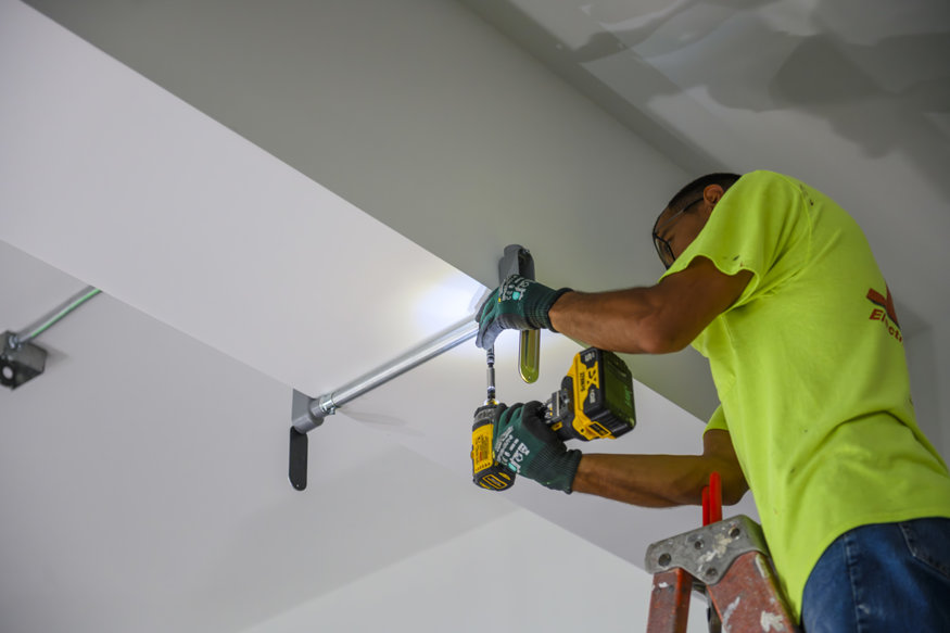 Temporary electrical conduit mounted above interior space.