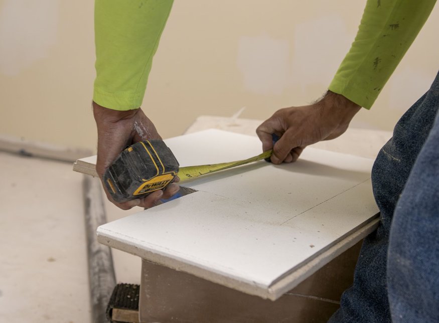 Ceiling tiles being installed.