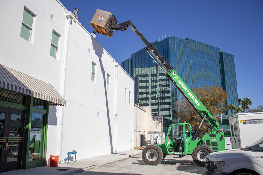 Pallets of solar panels lifted to the rooftop.