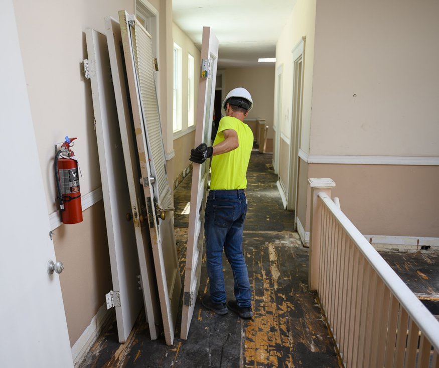  Stack of removed wooden doors in hallway.