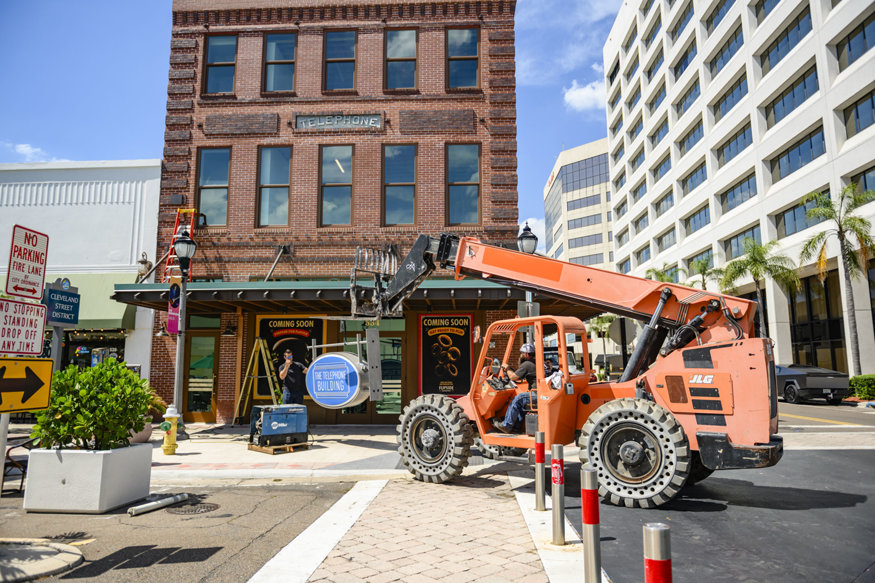 Lift equipment supports Telephone Building sign installation. 