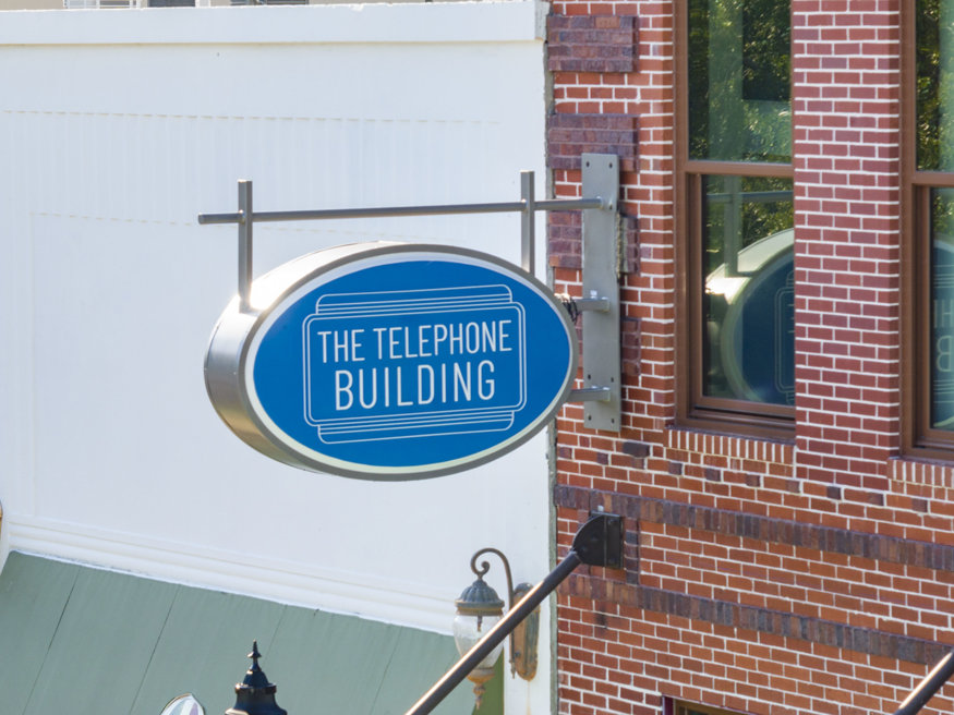 Blue Telephone Building sign projects from restored façade. 