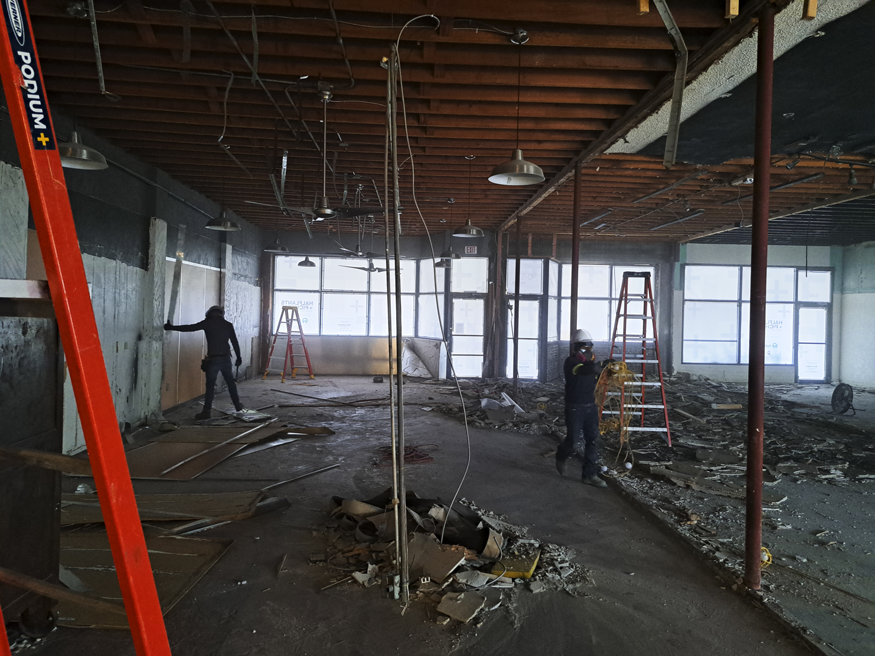 Construction crew removing debris and non-original materials inside 645 Cleveland Street during demolition.