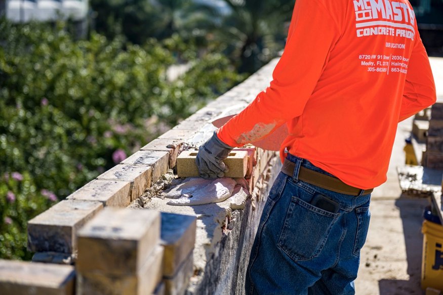 Crew lay bricks on the parapet.