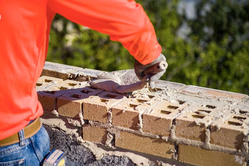 Crew member fills in the bricks with new mortar. 