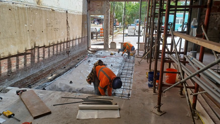 Construction crew prepares space for stairwell reinforcements.