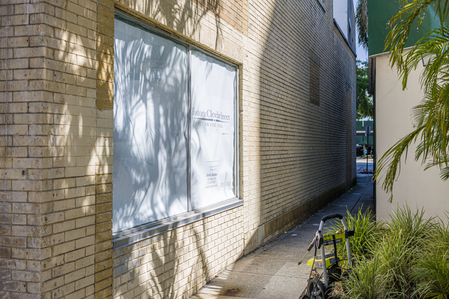 Partially cleaned east façade showing washed and painted brick.