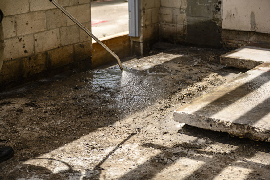 Treatment wand sprays soil beneath future concrete area.