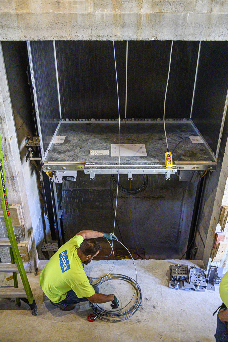 Cab is installed along the guide rails secured inside elevator shaft.