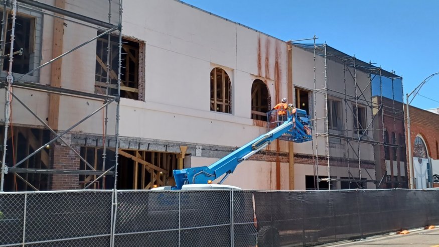 Wide view of east façade showing the completed saw cuts and safety scaffolding in place.