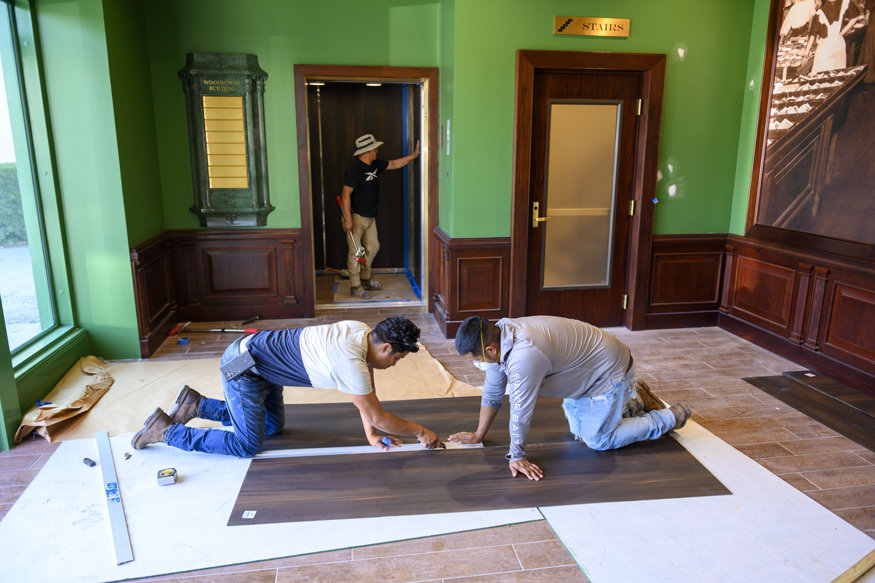 Measuring wood panels for elevator interior.