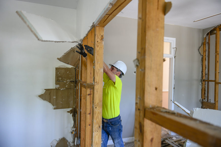 Historic wood framing is visible behind old, removed drywall.