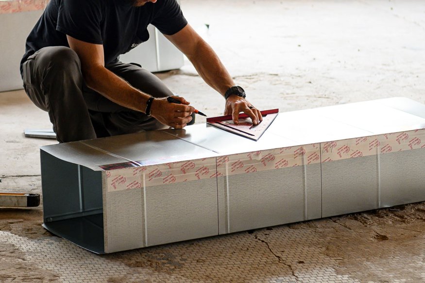 Worker marking duct for cutting.