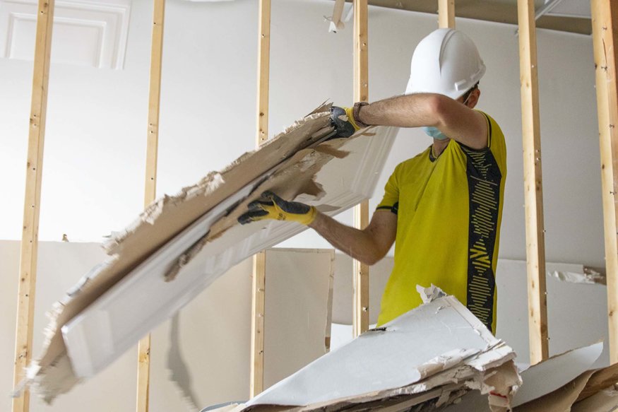 Workers removing drywall panels.