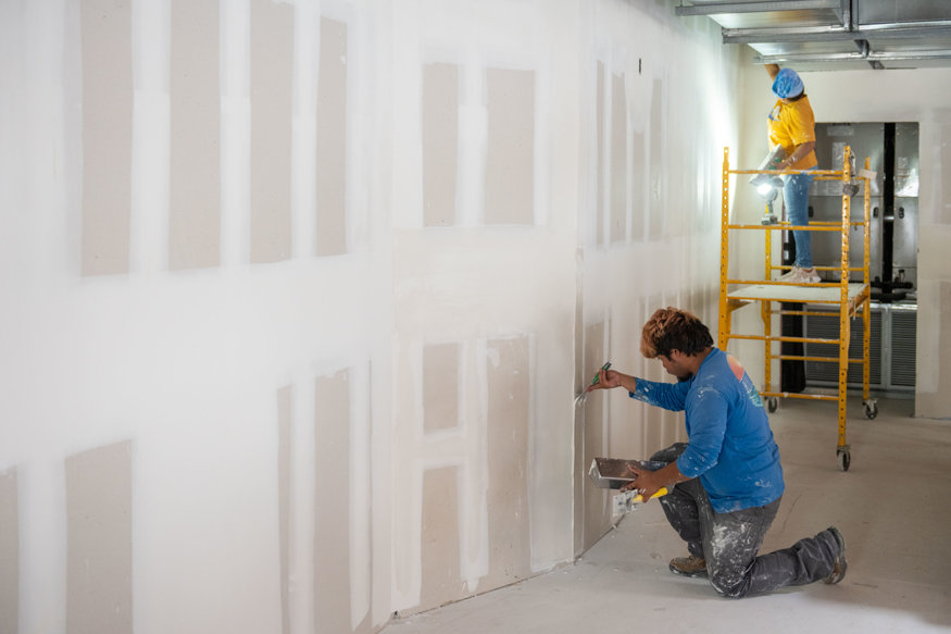 Second-floor walls receive detailed drywall finishing. 