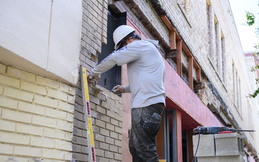 Bricklayer working on the storefront.