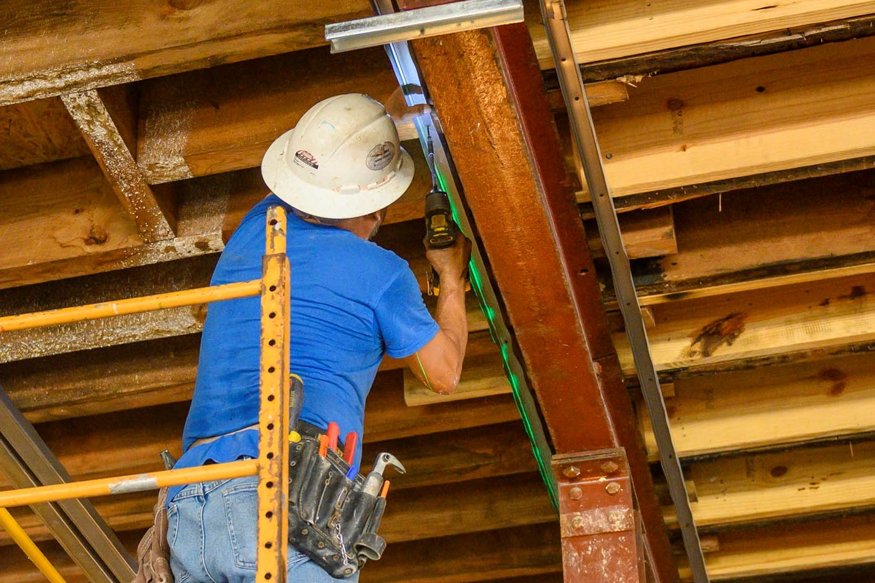 Framers install top horizontal pieces around beams.