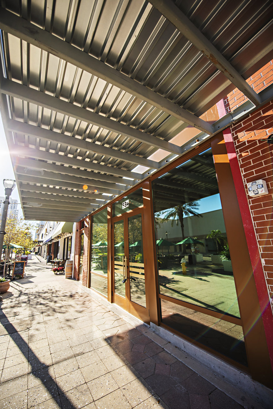 Exterior view of the restored Telephone Building featuring new storefront glazing and mid-century architecture under a modern metal awning.