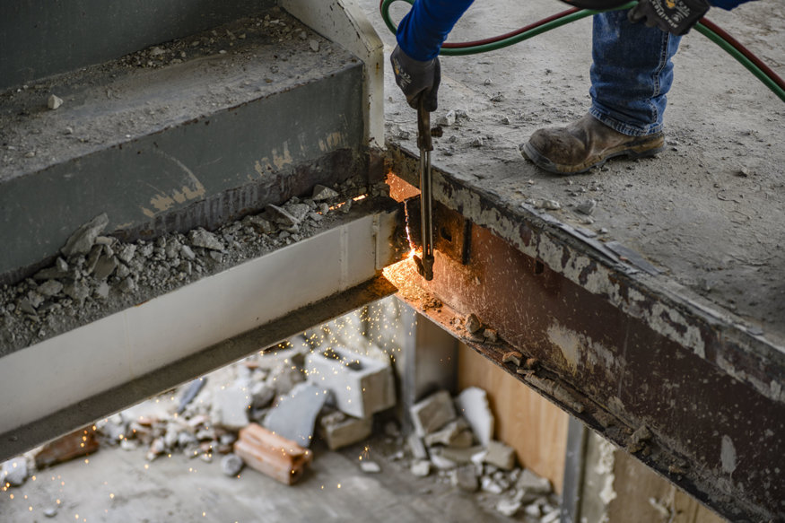Torch cutting steel stair supports during interior demolition.
