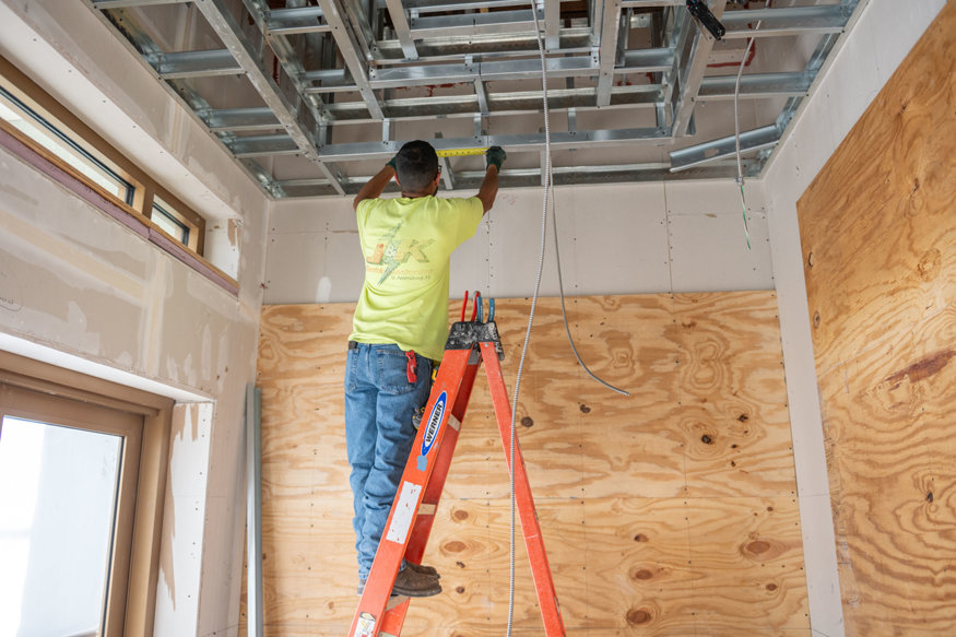 Metal conduit aligned within steel framing for wiring.