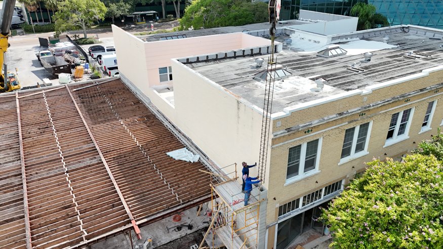 Crane lifts rebar cage toward newly constructed front columns.