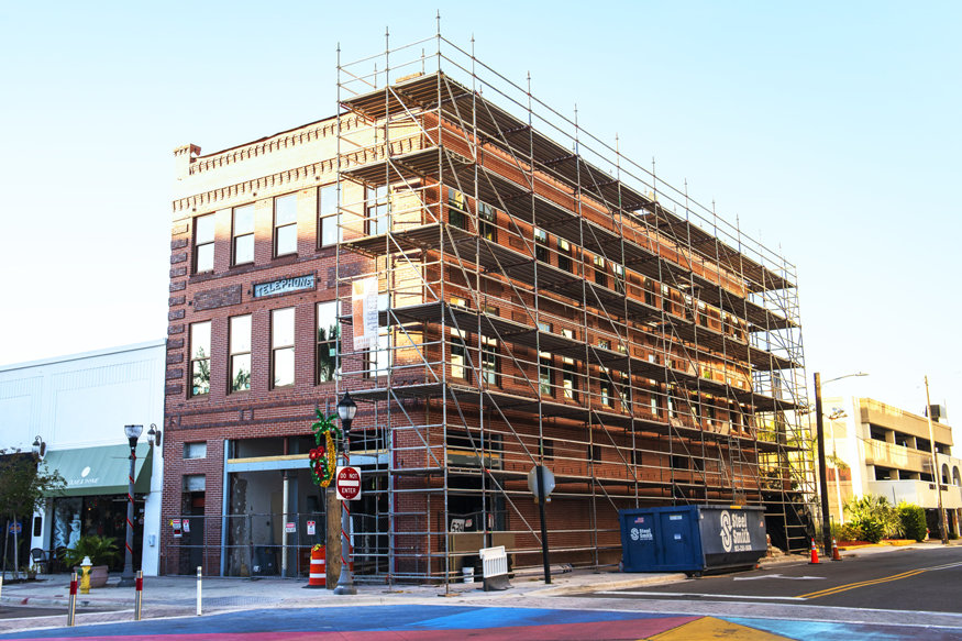 Scaffolding surrounds the brick-clad historic Telephone Building during window restoration.