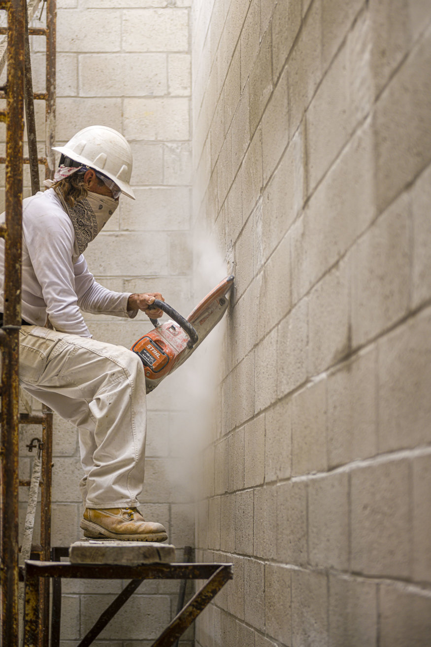 a crew member with a saw refining the stairwell
