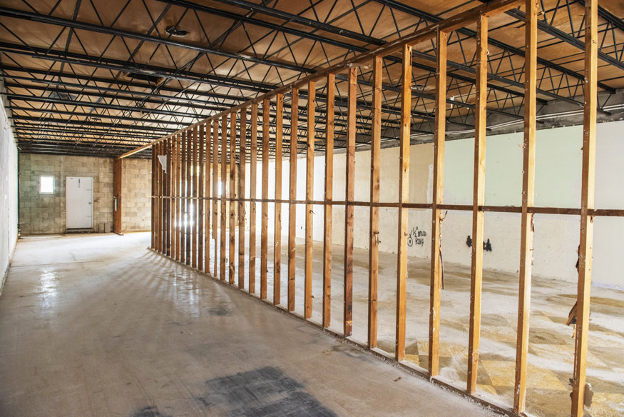 Interior view of 629 Cleveland Street with exposed framing and concrete floor during structural assessment.