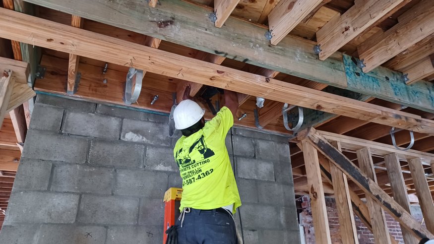 Workers rebuilding elevator shaft with concrete blocks.