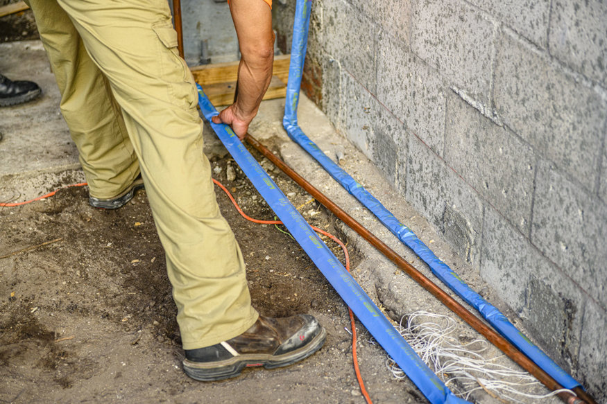 Worker positions blue domestic water line.