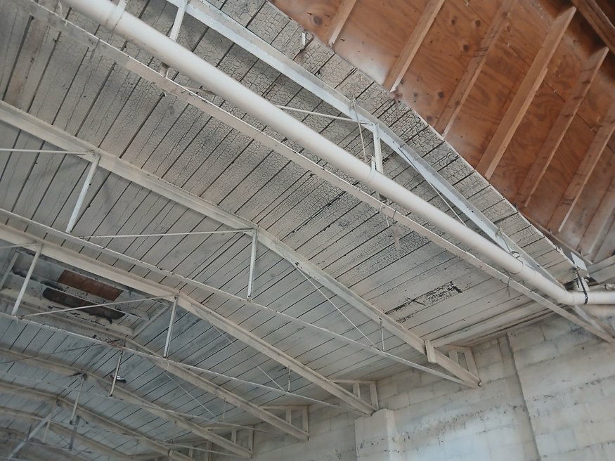 Detailed view of charred wooden ceiling boards exposed at 635 Cleveland Street during interior demolition.