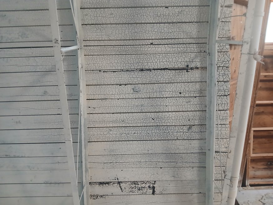 Charred wood ceiling and blistered surface texture seen after demolition at 635 Cleveland Street.