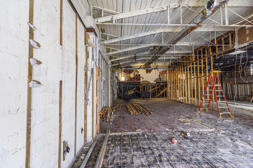 Wide view of demolition progress at 635 Cleveland Street showing early signs of fire char on ceiling beams.