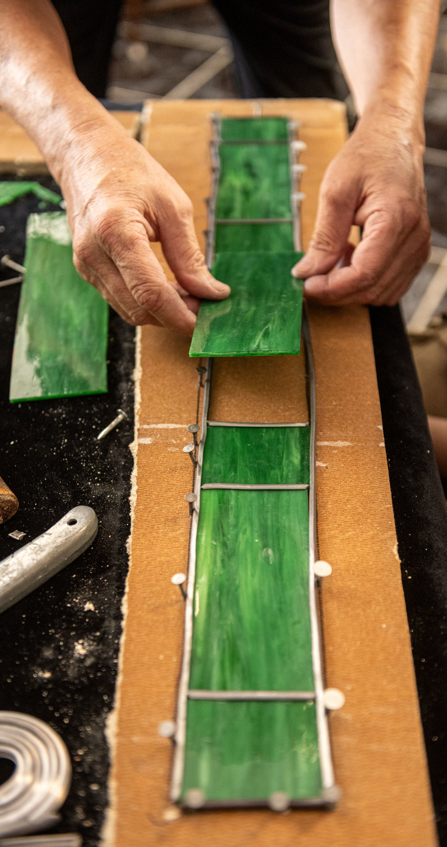 Horologist places green glass into the Peoples Bank clock frame.