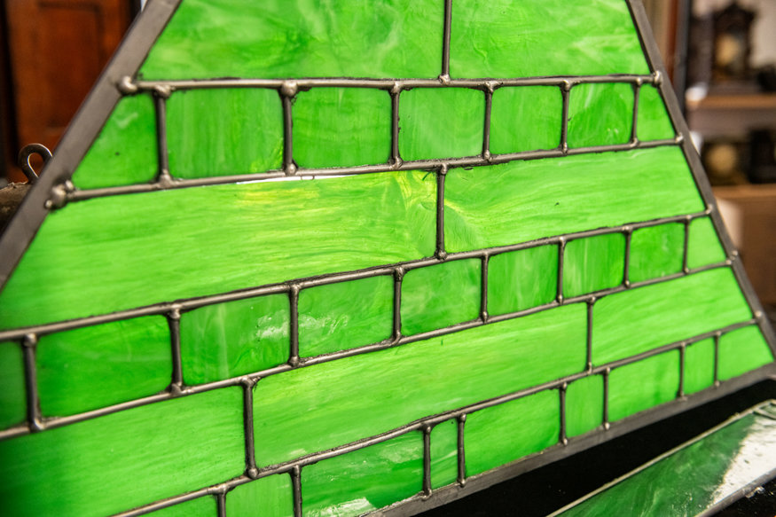 Green stained-glass panels set inside a restored clock frame.