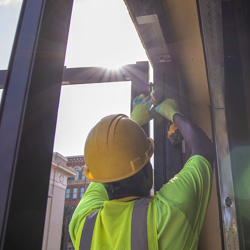Worker installing storefront door.