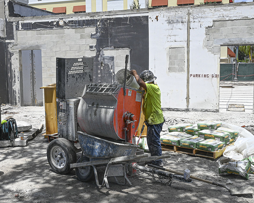 Worker mixes mortar for masonry wall reconstruction.