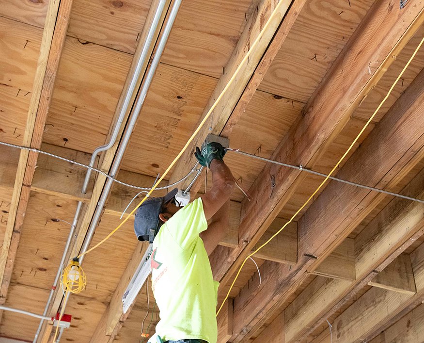 Electrical wiring routed through exposed ceiling framing. 