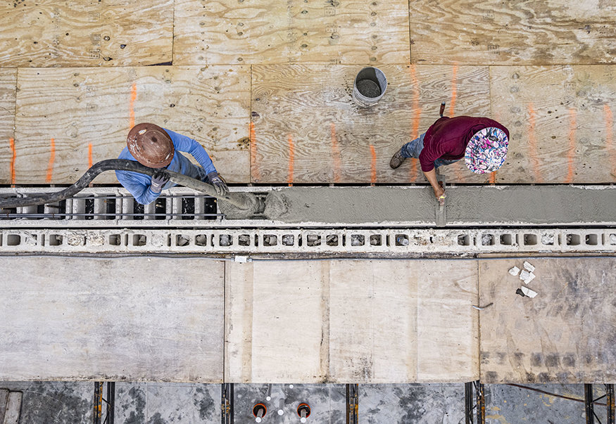 Concrete fills rebuilt parapet masonry from above.